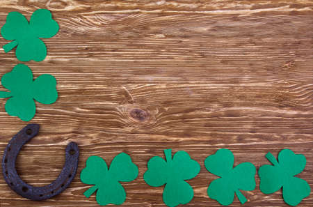 Fabric green clover leaves with horseshoe on wooden background.の写真素材