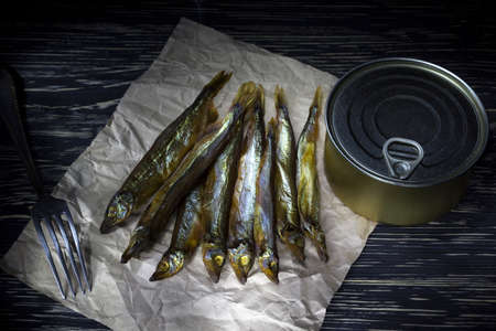 Smoked capelin and conserve tins on dark wooden backgroundの写真素材