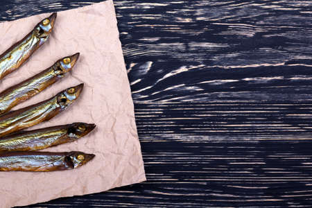 Smoked  capelin on dark vintage wooden background, top viewの写真素材