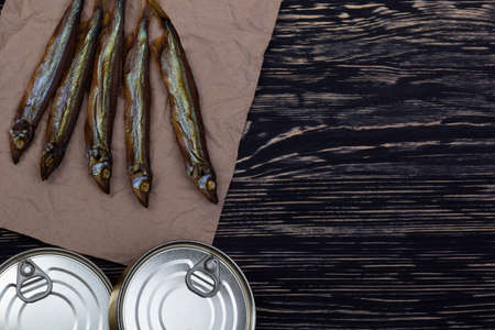 Smoked capelin and conserve tins on dark wooden backgroundの写真素材