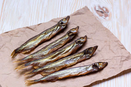 Smoked  capelin on light vintage wooden background, top viewの写真素材