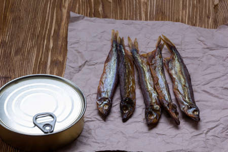 Smoked capelin and conserve tins on brown  wooden backgroundの写真素材