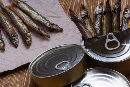 Smoked capelin and conserve tins on brown  wooden backgroundの写真素材