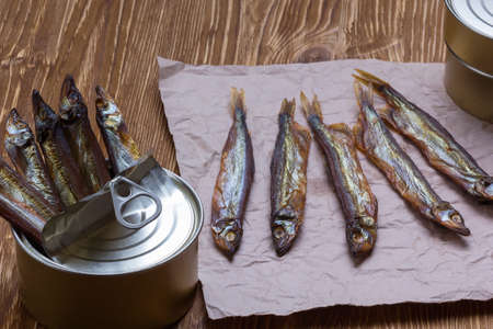 Smoked capelin and conserve tins on brown  wooden backgroundの写真素材