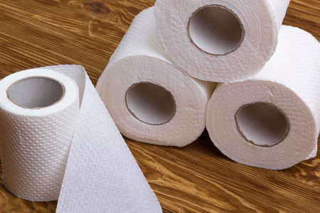 Rolls of toilet paper on wooden board