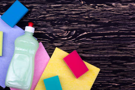 sponges, rsgs and a bottle of detergent on wooden backgroundの写真素材