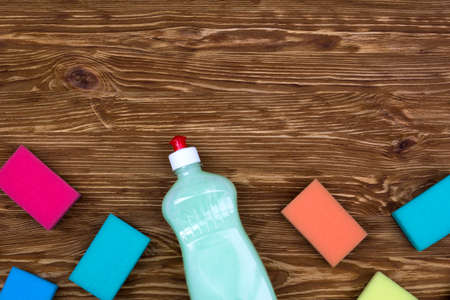 sponges and a bottle of detergent on wooden backgroundの写真素材