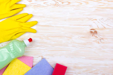 sponge, rsgs and a bottle of detergent on wooden background