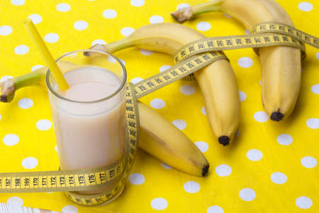 Banana juice with bananas and measuring tape on the wooden backgroundの写真素材