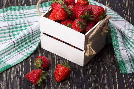 Strawberries in wooden box on wooden deskの写真素材