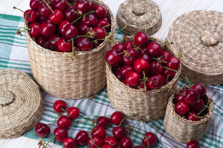 Cherry baskets on the white wooden deskの写真素材