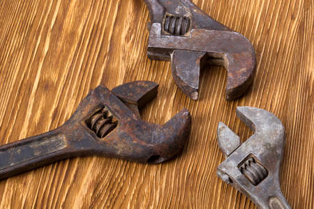 Closeup adjustable wrenches on a wooden background