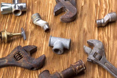 adjustable wrench and pipes on the wooden deskの写真素材