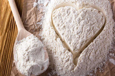 Heart of flour on the wooden backgroundの写真素材