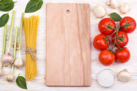 Pasta ingredients. Tomatoes, pasta, garlic basil, champignon and salt on wooden backgroundの写真素材