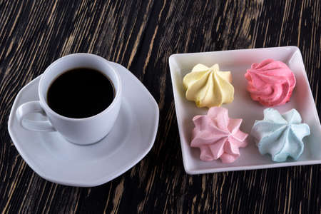 Meringue Cookies and cup of coffee on wooden background.の写真素材