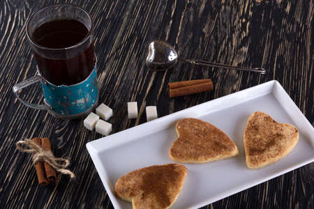 Glass of tea with cinnamon cookies on wooden background.の写真素材