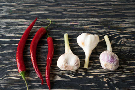 Red hot chili peppers and garlic on dark wooden backgroundの写真素材