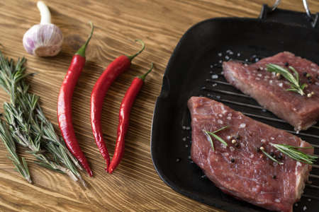 pan of fresh meat with rosemary and pepper, top viewの写真素材