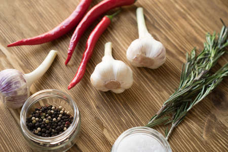 Red hot chili peppers, rosemary and garlic on dark wooden backgroundの写真素材