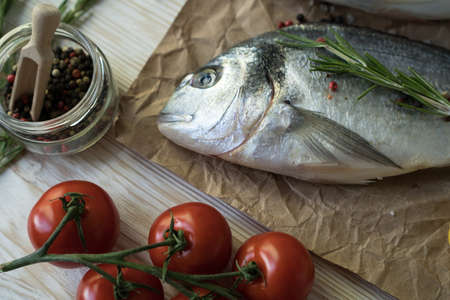 Raw fish cooking and ingredients. Dorado, lemon, herbs and spices.
