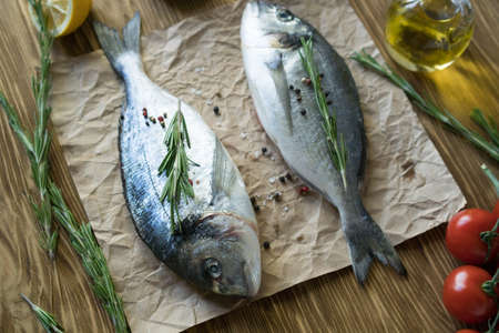 Raw fish cooking and ingredients. Dorado, lemon, herbs and spices.の写真素材