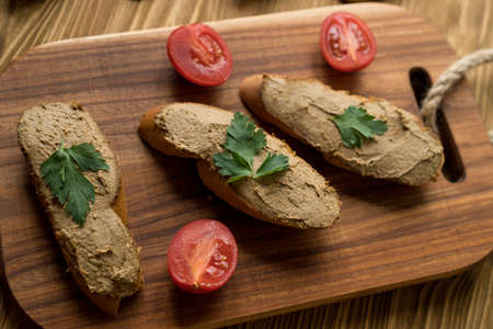 Liver pate on the bread on wooden tray.の写真素材