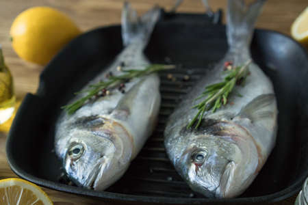 Raw fish cooking and ingredients. Dorado, lemon, herbs and spices.