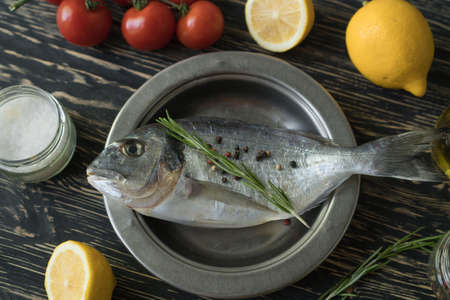 Raw fish cooking and ingredients. Dorado, lemon, herbs and spices.の写真素材