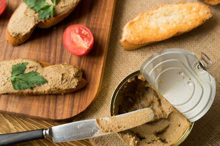 Liver pate on the bread on wooden tray.