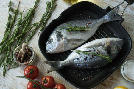 Raw fish cooking and ingredients. Dorado, lemon, herbs and spices.