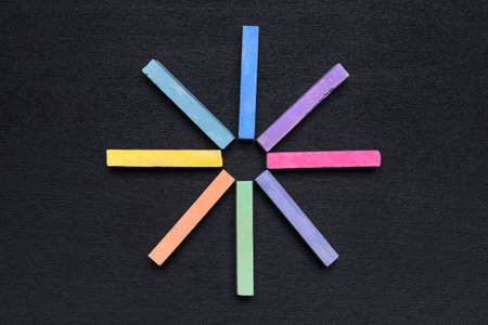 multicolored crayons for children's creativity folded rays on a black chalk board