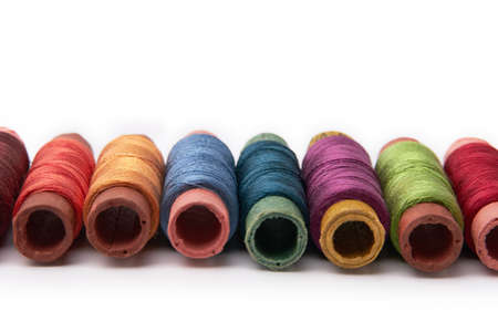 Set of spools with multicolored threads, photographed on a white backgroundの写真素材