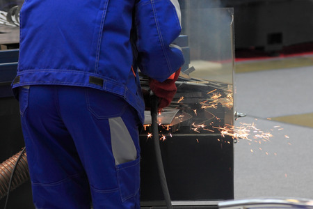 Factory worker in working clothes welding metal construction.の写真素材