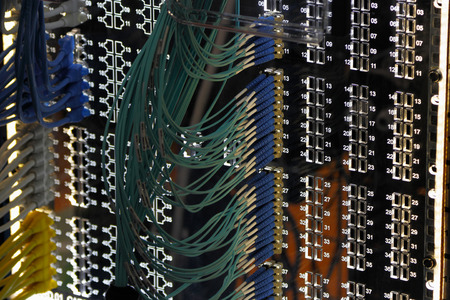Networking patch panel with ethernet and fiber optic cables.