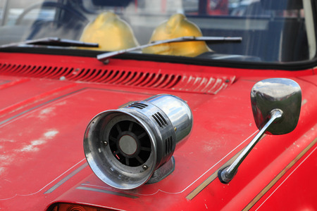 Closeup of old fire truck with a siren on the fender.