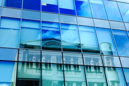 Facade of modern office glass building with reflection.