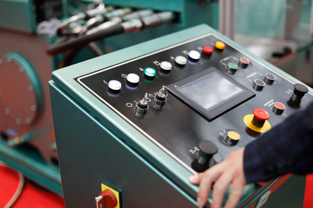 Operator working with a control panel of modern metalworking machine. Selective focus.