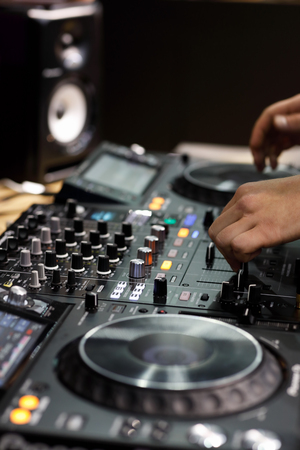 Professional 4 channel DJ controller with hands of DJ. Selective focus.
