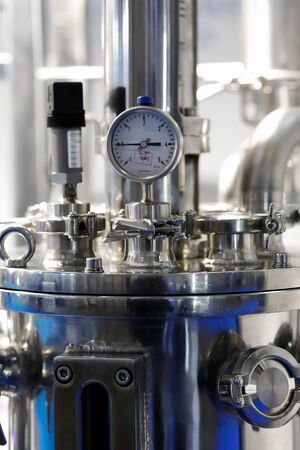 Stainless steel industrial equipment with pressure gauge. Selective focus.