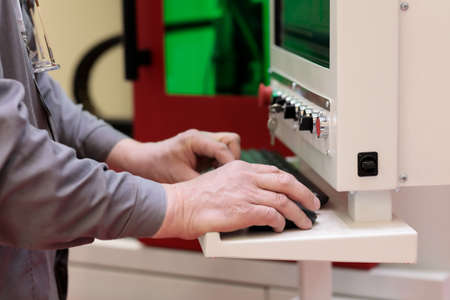 Operator programs the laser cutting and engraving machine. Selective focus.の写真素材