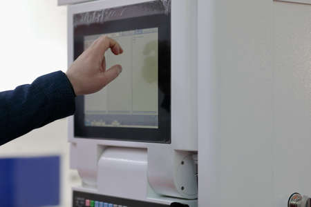 Engineer controls modern industrial equipment by touchscreen. Selective focus.の写真素材