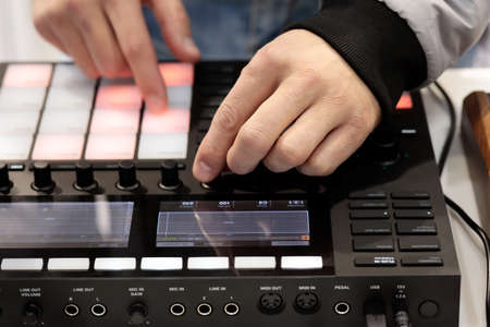 DJ mix and plays music using MIDI controller. Selective focus.