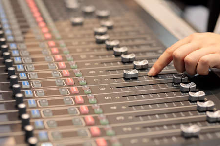 Audio mixing console with the hand of sound engineer. Selective focus.の写真素材