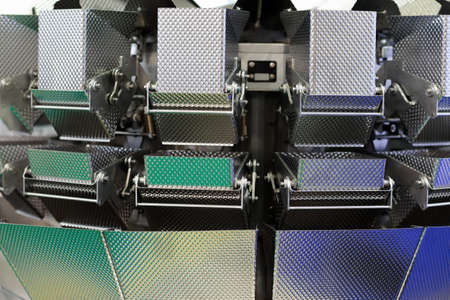 Close up of multihead weigher with stainless steel buckets. Selective focus.の写真素材