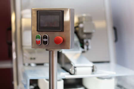 Console with touch screen industrial control panel in food production plant. Selective focus.