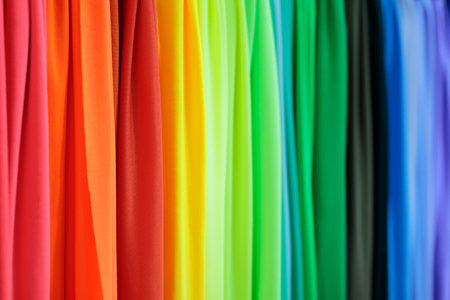 Multicolored fabrics samples in textile store. Abstract rainbow colored background. Selective focus.の写真素材