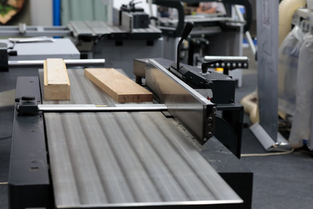 Wood cutting table circular saw machine. Sliding table saw in woodworking workshop. Selective focus.