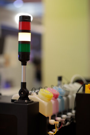 Industrial tower signal lights mounted on large format inkjet printer. LED signal stack lights....