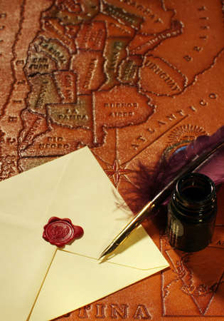 Still-life with a letter, a quill and an inkwell on a background of a map of South Americaの写真素材